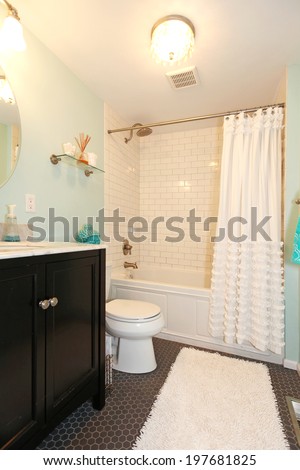 Aqua bathroom with dark floor and tile wall trim. View of bathroom vanity with mirror