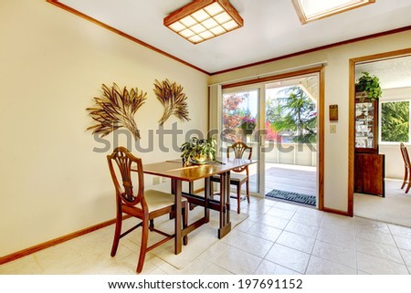 Bright dining area in kitchen room. View of dining table set and walkout deck