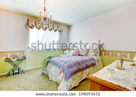 Comfortable bedroom with walls in pink and lime colors. View of bed with colorful bedding