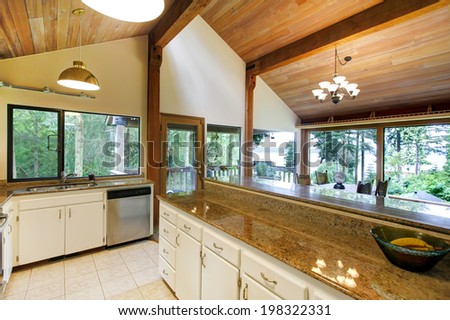 Log cabin house interior. View of white kitchen room with steel appliances