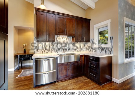 Kitchen storage combination in dark brown color with steel stainless appliances