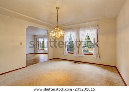 Empty living room with carpet floor and white curtains on the window