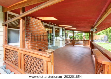 View of wooden backyard covered deck with railings