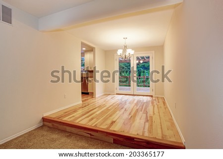 Ivory empty room with hardwood floor and walkout deck.