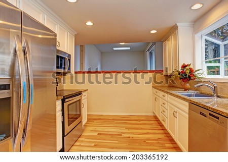 Small kitchen room with steel appliances.