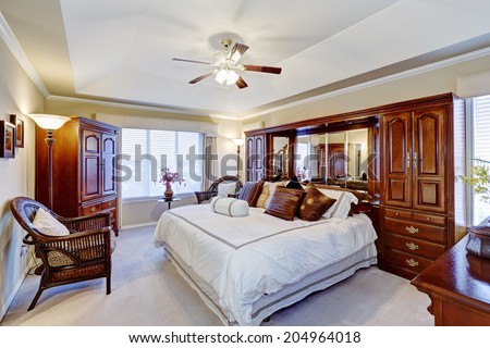 Luxury master bedroom interior with rich brown furniture set