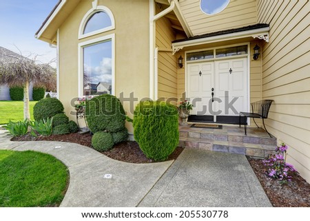 Luxury house entrance porch with walkway and trimmed hedges