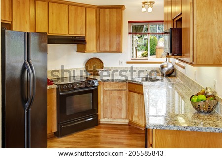 Bright small kitchen room interior with black appliances
