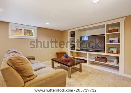 Cozy room in soft brown color with comfortable sofa, coffee table and tv