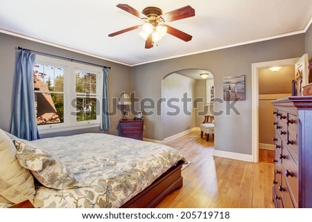 Master bedroom interior in light grey color. View of queen size bed and dresser