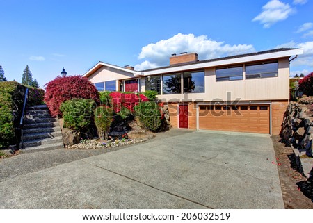 Modern house exterior with curb appeal. View of garage and driveway