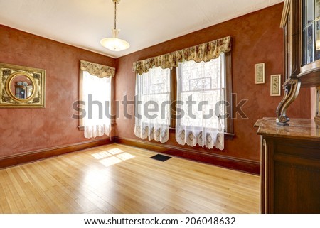 Empty bright red room with curtains and antique cabinet