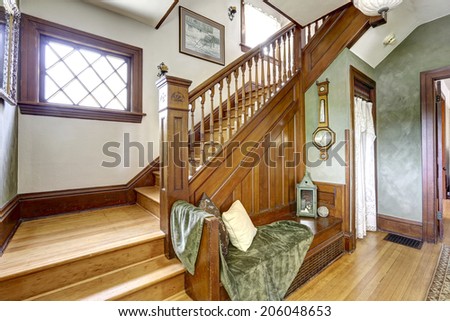 View of staircase and bench decorated with pillows and green blanket