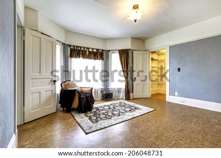 Empty bedroom with walk-in closet. Decorated with single antique armchair