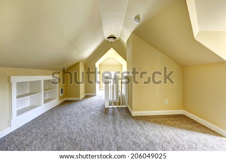 Empty bedroom in soft ivory with soft brown carpet floor and vaulted ceiling