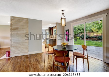 Dining area with walkout deck, hardwood floor. View of black round table with brown chairs