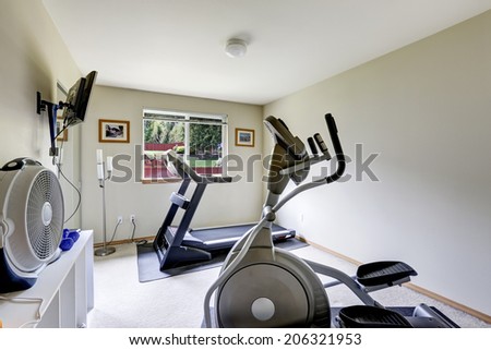 Bright gym room with exercise equipments and tv