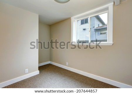 Small empty room with window and carpet floor.