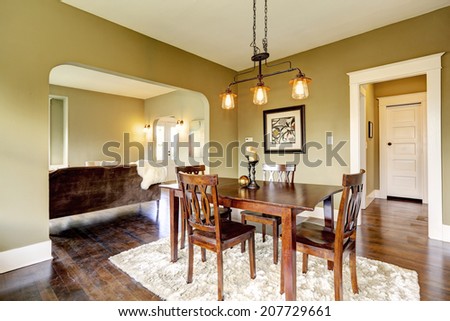Open floor plan. Dining area with dark brown dining table set and soft rug on hardwood floor