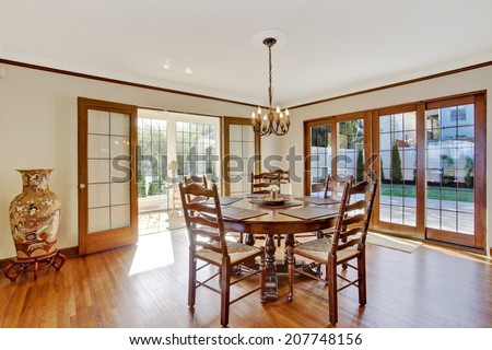 Bright dining room in luxury house with french door to walkout deck. Corner decorated with china vase