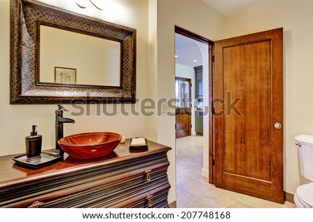 Bathroom interior in luxury house. View of rich bathroom vanity cabinet with vessel sink and mirror