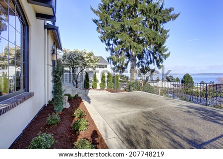 Spacious walkout deck with concrete floor and railings overlooking front yard and driveway