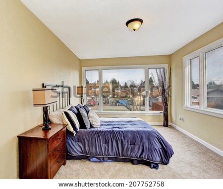 Bright ivory bedroom interior with carpet floor and queen size bed in purple