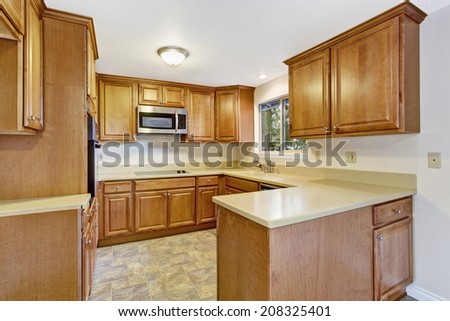 Bright kitchen interior in empty house with linoleum and ivory counter tops