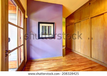 Empty hallway with bright purple wall and glass exit door