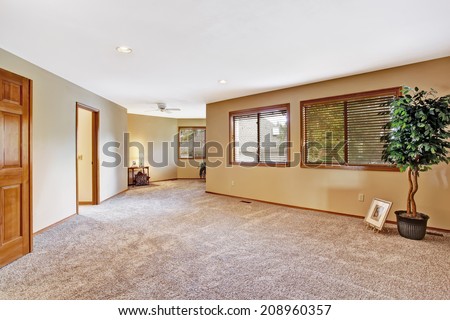 Empty room in luxury house with windows and soft brown carpet.