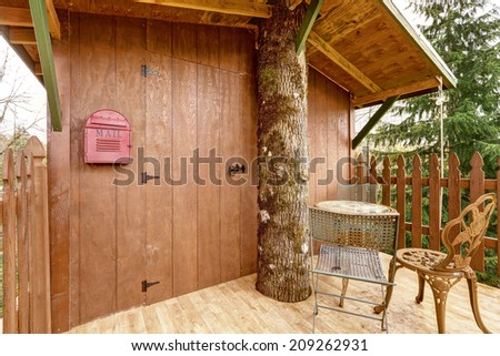 Small tree house with walkout deck. View of entrance door with mail box