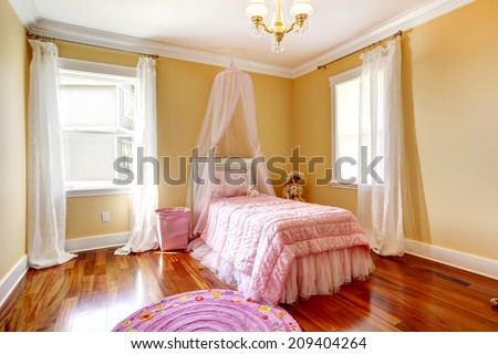Bright girl room in ivory color with soft pink canopy bed