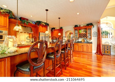 Bright luxury kitchen with rich carved wood stools and granite counter top