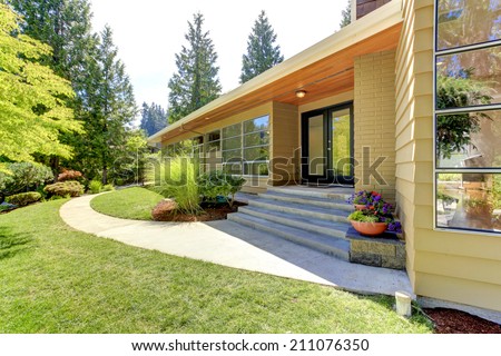 House exterior with curb appeal. View of entrance porch with stairs and front yard landscape