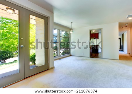 Empty house interior. Room with carpet floor and glass wall. View of glass door to backyard