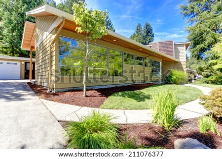 House exterior with curb appeal. View of garage and driveway. Front yard landscape design