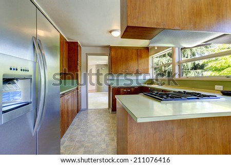 Kitchen room in empty house. View of wooden storage combination with and light green tops