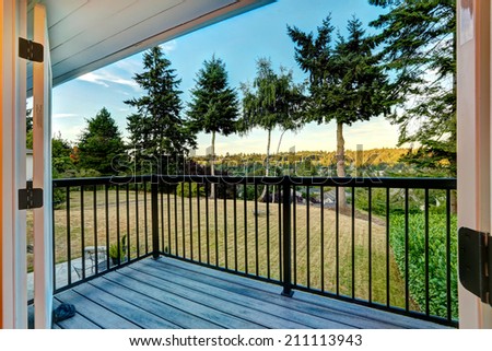 Walkout deck with railings overlooking backyard area