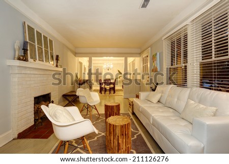 Living room with cozy fireplace. Furnished with antique chests and modern sofa and chairs