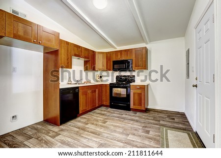 Kitchen cabinets with black appliances and white tile wall trim