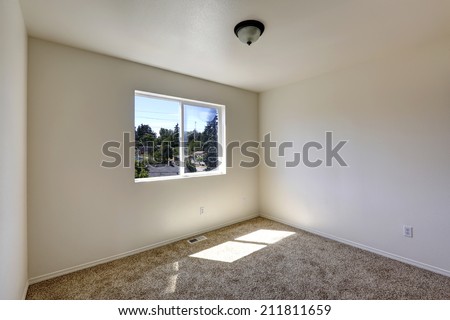 Empty house. Simple room with window and brown soft carpet floor