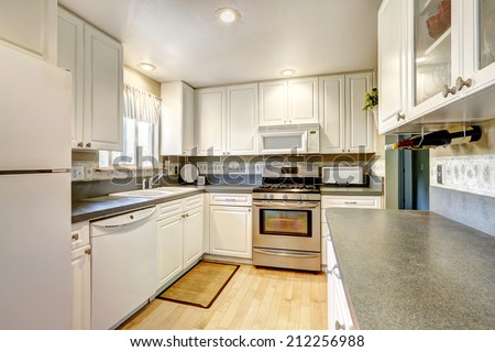 Simple white kitchen with steel stove and granite tops