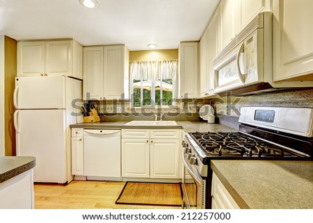 Simple white kitchen with steel stove and granite tops