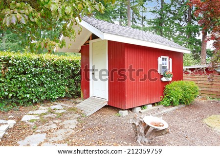 Bright red wooden shed on backyard area