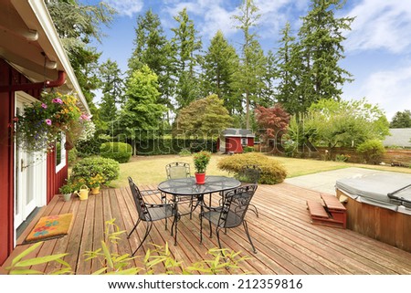 Beautiful bright red house with patio area on walkout deck and small red shed on backyard