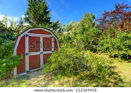 Home secret garden on backyard with small red barn shed