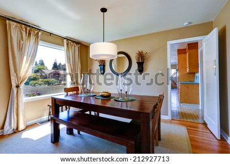 Soft beige dining room with massive wood table decorated with candles