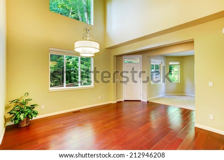 Empty house interior. Foyer with high ceiling and hardwood floor