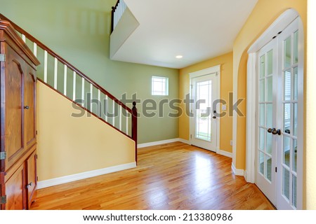 Bright entrance hallway in mint and yellow colors with staircase