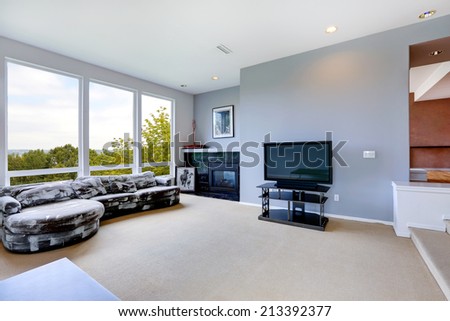 Light blue living room interior with tv, fireplace and white and black couch